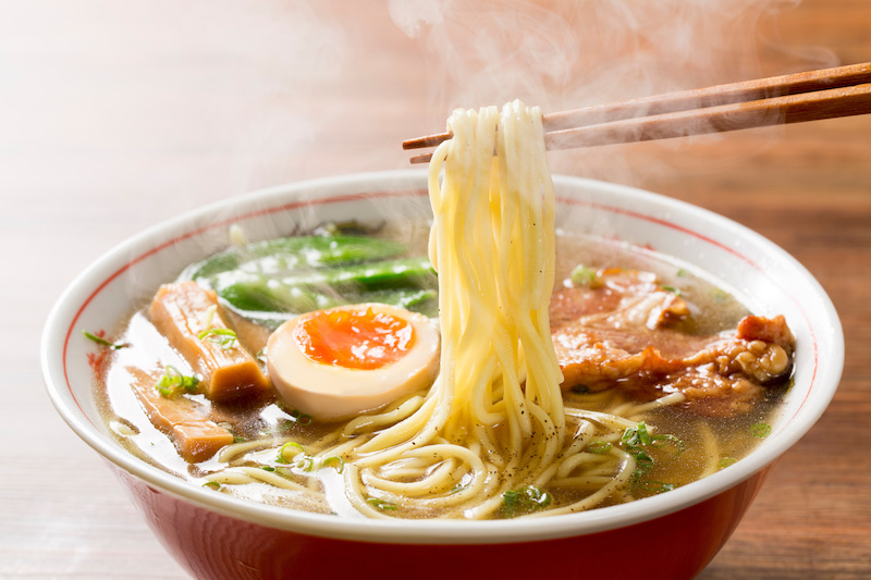 熱々の醤油ラーメンを箸で摘む図